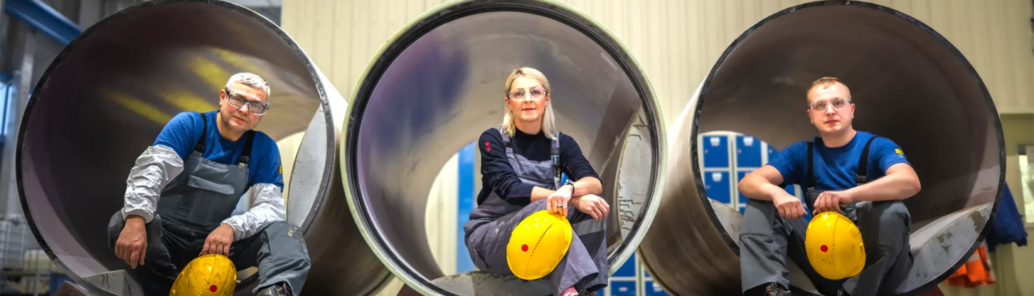 blue-collar workers sitting inside GRP pipes at Amiblu Poland