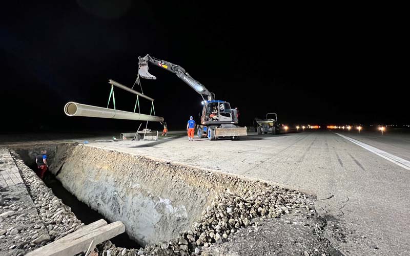 GFK-Rohrleitung hängt an Traverse zum Transport in die Baugrube